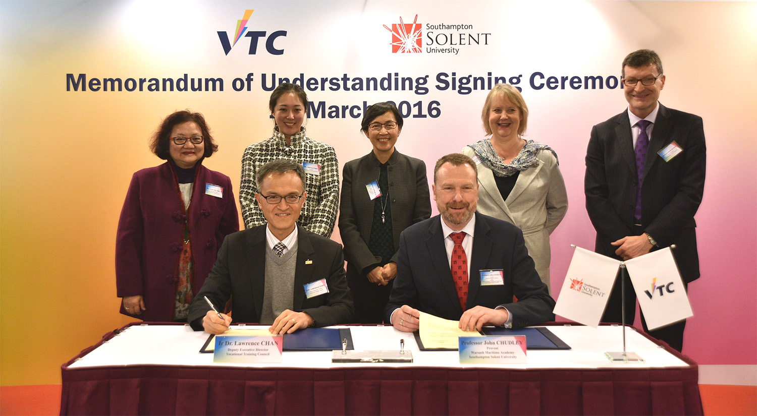 VTC Deputy Executive Director, Dr Lawrence CHAN (first on left, front row) and Professor John CHUDLEY (first on right, front row), Provost, Warsash Maritime Academy, Southampton Solent University, signed the Memorandum of Understanding in the presence of (from the left, back row) VTC Executive Director Carrie YAU, Sabrina CHAO, Chairman of Hong Kong Shipowners Association; Director of Marine Maisie CHENG; Frances MOFFETT-KOUADIO, British Trade Commissioner to Hong Kong and Macao, and Professor G