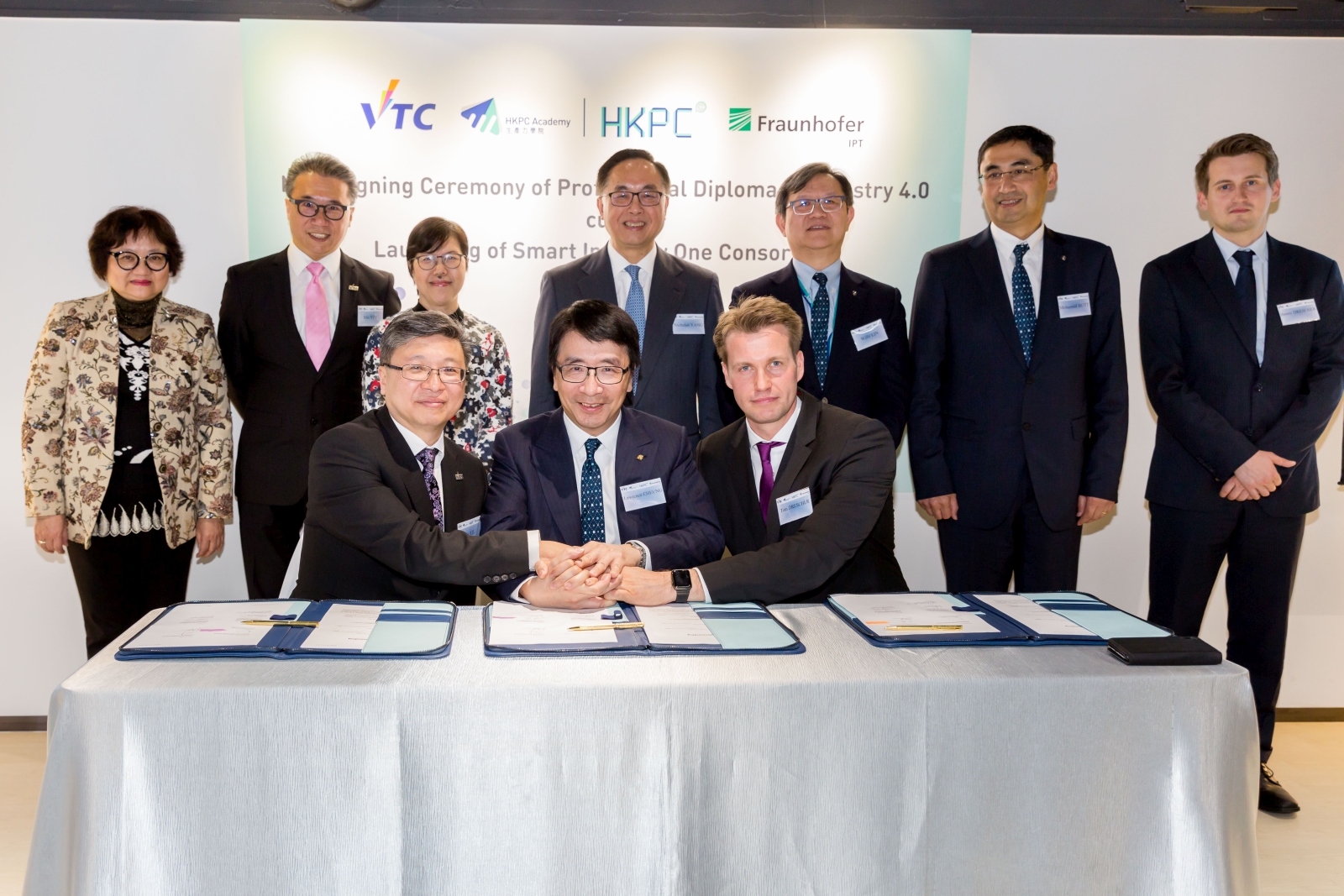 Witnessed by Mr Nicholas Yang, Secretary for Innovation and Technology of the HKSAR Government (back row, centre), Dr Lawrence Cheung, Director (Technology Development) of HKPC (front row, centre); Dr Eric Liu, Deputy Executive Director of VTC (front row, left); and Mr Toni Drescher, Head of Technology Management of Fraunhofer IPT (front row, right), sign the MoU for Hong Kong’s first Professional Diploma Programme in Industry 4.0