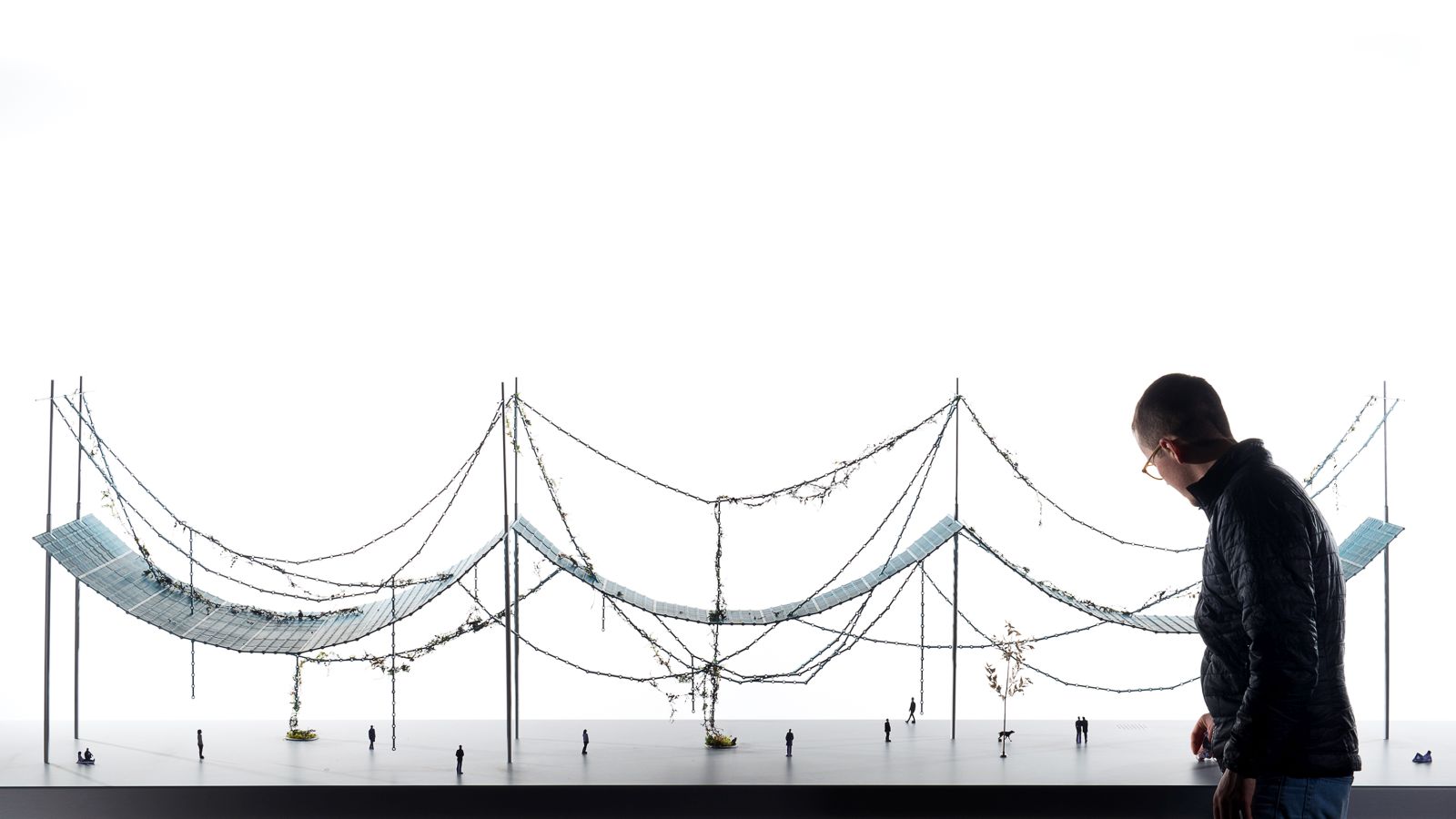 「Pergola」尤如一塊連綿的布,以重複的植被金屬單元組成如建築鏈串般的超巨型天幕,使其底部形成往外延伸的遮陰長廊。結構亦局部性地為地面植物打開缺口,讓它們穿過涼棚生長,創造了金屬和植物互相纏繞的聯繫。 © Studio Bouroullec