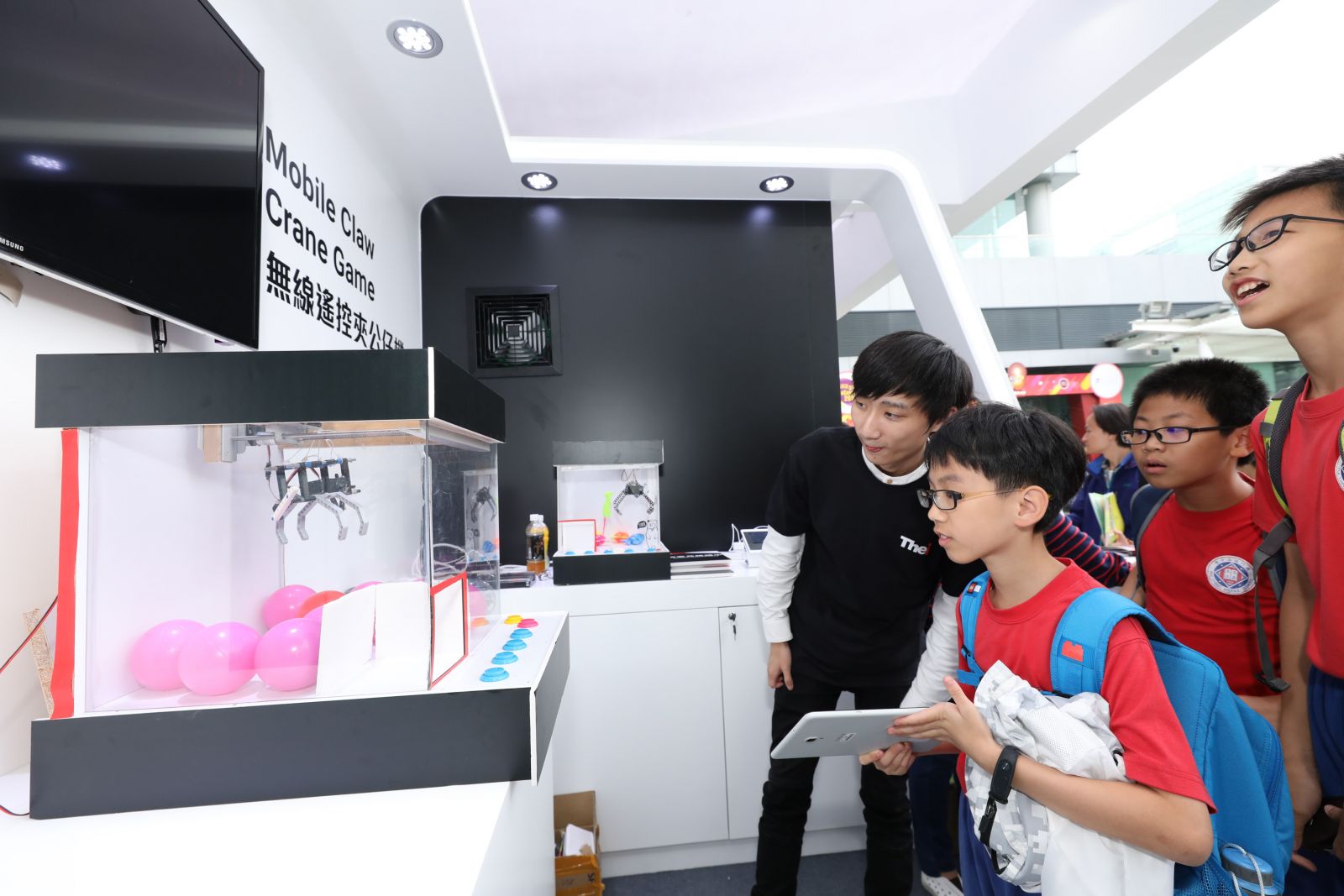 Visitors play the “Mobile Claw Crane Game”, using the smartphone and built-in sensors to remote control the robotic arm within the crane